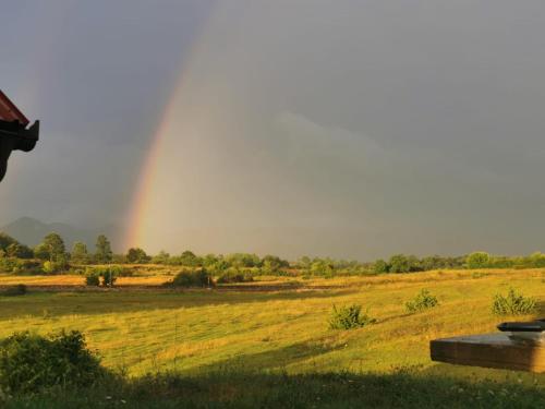 a rainbow in the sky over a field at Wooden House Sveti Rok in Sveti Rok