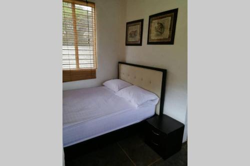 a small bed in a room with a window at FINCA YULUKA in Apulo