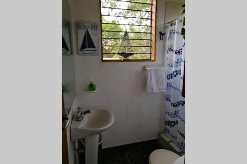 a bathroom with a sink and a toilet and a window at FINCA YULUKA in Apulo
