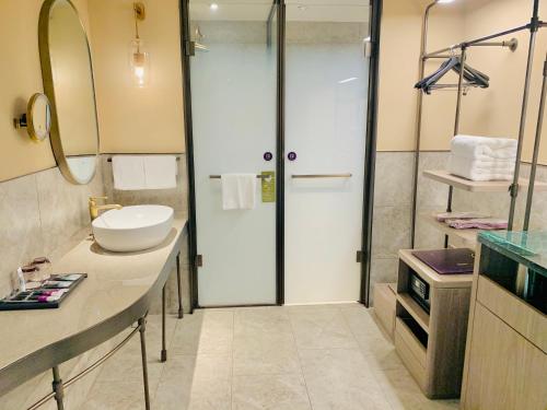 a bathroom with a shower with a sink and a toilet at Mercure Fuzhou Downtown in Fuzhou
