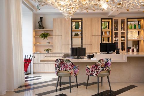 - une cuisine avec un bar avec deux chaises et une table dans l'établissement Hôtel des Champs-Elysées, à Paris