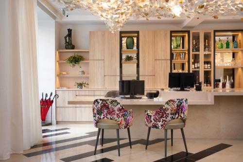 a kitchen with a bar with two chairs and a table at Hôtel des Champs-Elysées in Paris