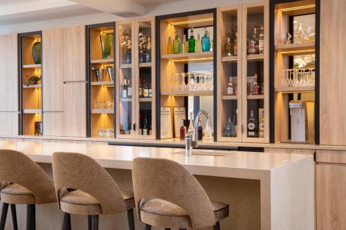 une cuisine avec un grand comptoir entouré de chaises dans l'établissement Hôtel des Champs-Elysées, à Paris