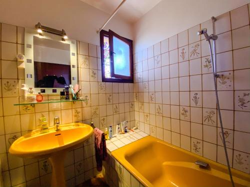 a bathroom with a yellow tub and a sink at 4AMB2 Villa de caractère avec piscine collective in Collioure
