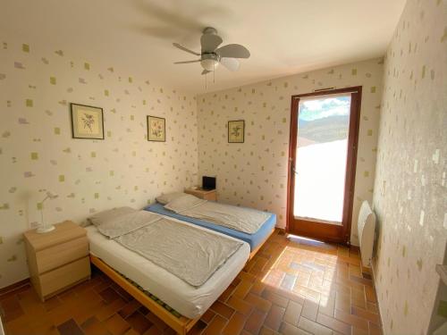 a small bedroom with a bed and a window at 4AMB2 Villa de caractère avec piscine collective in Collioure