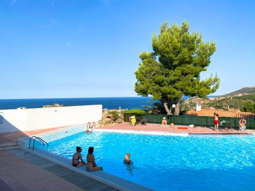 un groupe de personnes assises dans une piscine dans l'établissement 4AMB2 Villa de caractère avec piscine collective, à Collioure