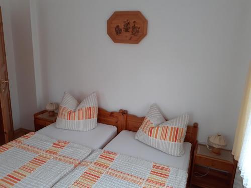 a bedroom with two beds and a clock on the wall at Ferienhaus Grabs in Lichtenhain
