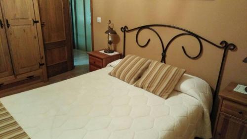 a bedroom with a white bed with a black frame at CASA ALTOBIERZO, 9 Habitaciones y 9 BAÑOS in Pobladura de las Regueras