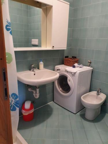 a bathroom with a washing machine and a sink at Lago Residence in Desenzano del Garda