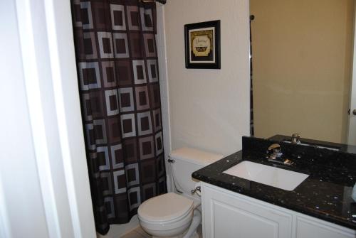 y baño con aseo y lavamanos. en Relaxing 4 Bedroom Home, en Conroe