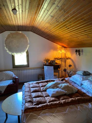 萬根伯格的住宿－L’hippocampe，一间卧室设有一张带木制天花板的大床