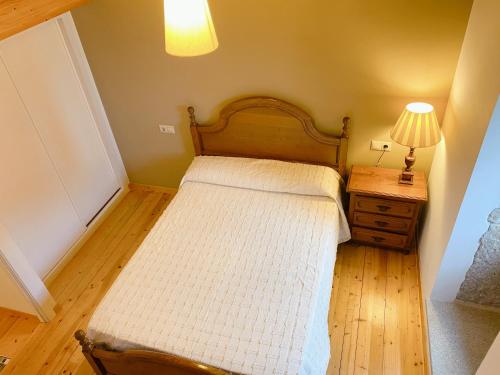 a small bedroom with a bed and a lamp on a table at A Casa de Feli in Muros