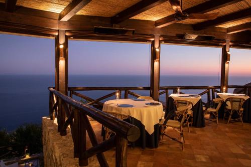 a restaurant with tables and chairs on a balcony at Monastero Santa Rosa Hotel & Spa in Conca dei Marini