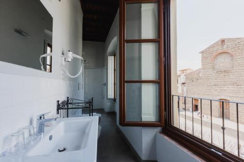 bagno con lavandino bianco e finestra di The Artists' Palace Florence a Firenze