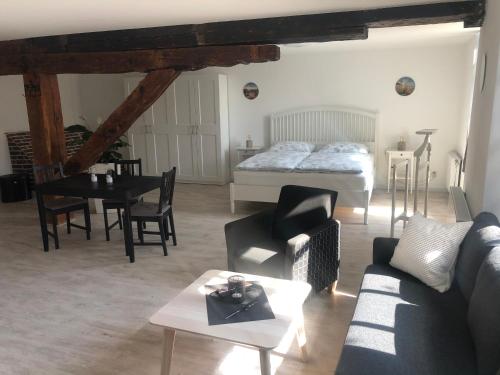 uma sala de estar com uma cama e uma mesa em Atelier Altstadt Stralsund em Stralsund