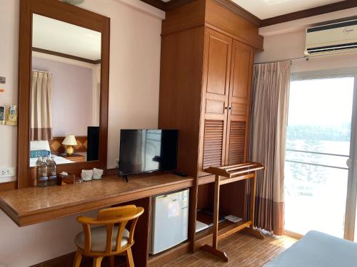 a room with a television and a desk with a mirror at Krabi River Hotel in Krabi town