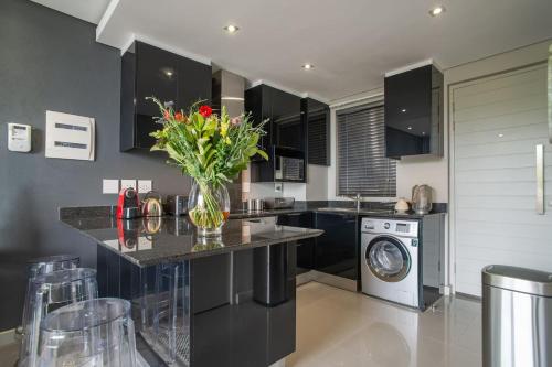 a kitchen with a vase of flowers on a counter at Lux Andringa Walk Apartments in Stellenbosch