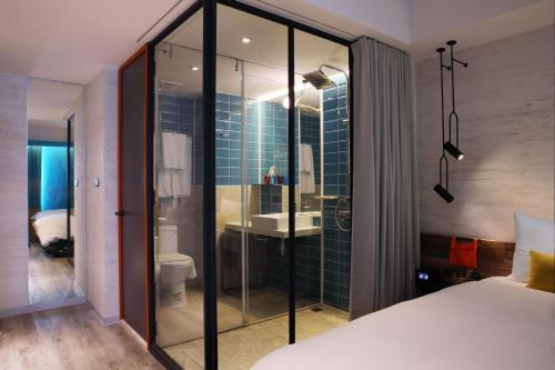 花蓮市的住宿－悅樂旅店- 花蓮中福，一间卧室,配有带水槽和卫生间的浴室