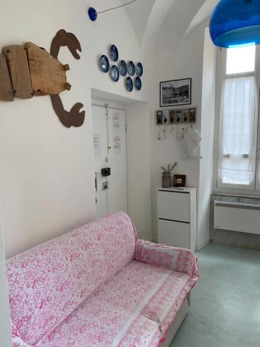 sala de estar con sofá rosa y ventana en Minisuite, en Lerici