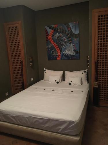 a bed with white sheets and pillows in a bedroom at Villa entière GOLF MARRAKECH in Marrakesh