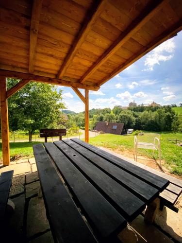 a wooden picnic table sitting under a wooden roof at Chalupa Kuks in Kuks