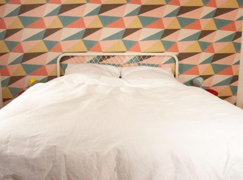 een wit bed in een kamer met een kleurrijke muur bij Ferienwohnung Marion in Oberwesel