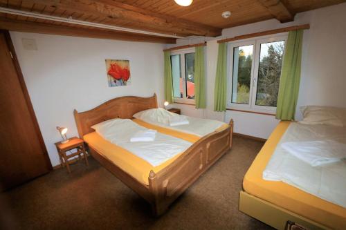 2 Betten in einem Zimmer mit 2 Fenstern in der Unterkunft juhui Flumserberg in Flumserberg