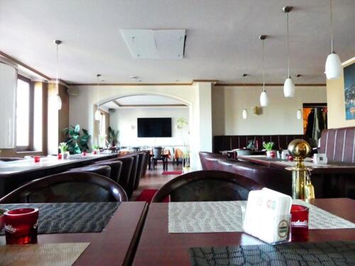 ケルンにあるホテル クニベルト デア フィーゼ スーペリアのテーブルと椅子のあるレストラン、バー