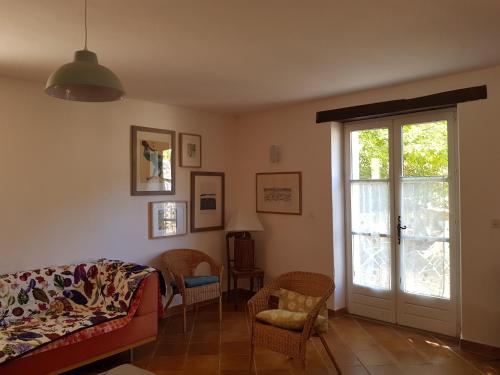 - un salon avec un canapé et une porte coulissante en verre dans l'établissement Mas du Cheval Long, à Sablet