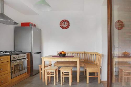 a small kitchen with a table and a refrigerator at Sosnowy Domek Krasnobród in Krasnobród