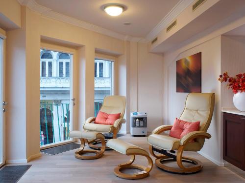 a waiting room with two chairs and a window at EA Apartmány Mozart in Karlovy Vary