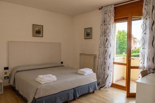 1 dormitorio con 1 cama y puerta corredera de cristal en Bed and Breakfast La Sosta, en Ponte San Nicolo
