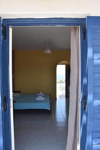 a room with a bed and an open door at Lofos Studios in Agios Prokopios