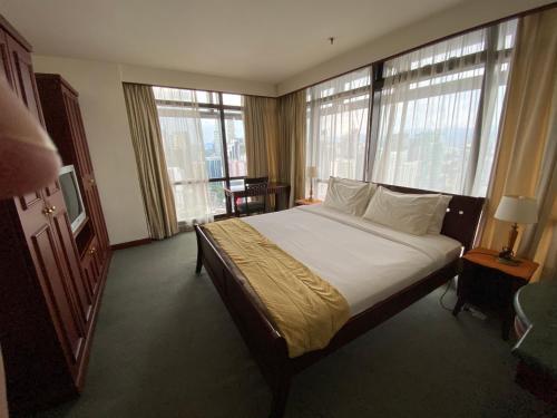 a bedroom with a large bed in a room with windows at Jenet Service Suite At Times Square KL in Kuala Lumpur