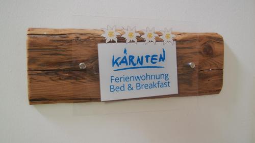 a sign hanging on a wall with flowers on it at Ferienwohnungen Themessl in Kirchbach