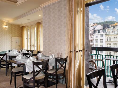 a dining room with tables and chairs and a window at EA Hotel Elefant in Karlovy Vary