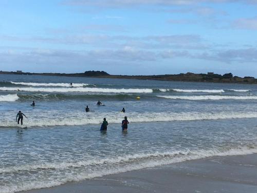 a group of people in the water at the beach at La maison Ti Billou in Santec