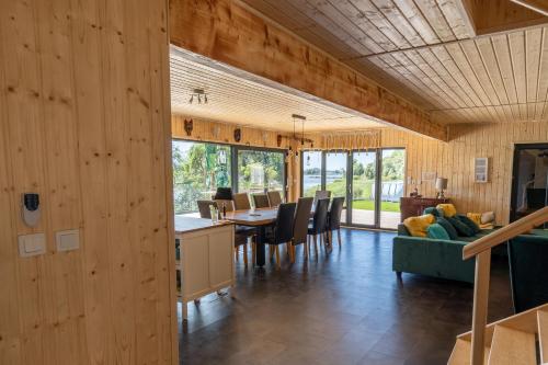 a dining room and living room with wooden walls at Houses with a View#Sauna#Jaccuzi in Gozdowice
