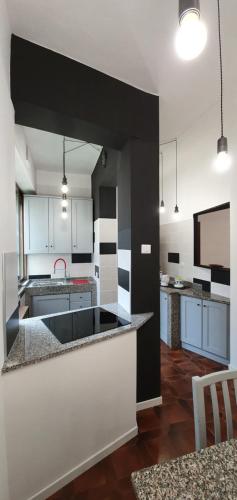 una cucina con armadi bianchi e piano di lavoro nero di 2 bed flat Centre & Stadio free parking a Terni