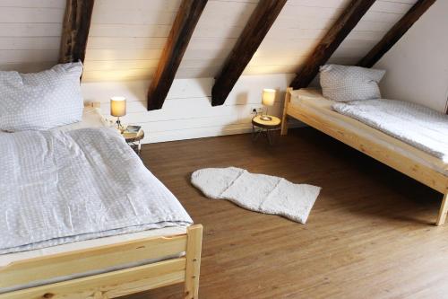 two beds in a room with wooden floors and beams at Workers Apartment in Frickenhausen mit TV & WLAN in Frickenhausen