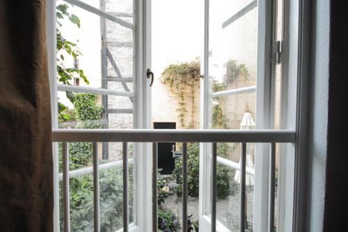an open window looking out at a garden outside at Sankt Annæ 10 in Copenhagen