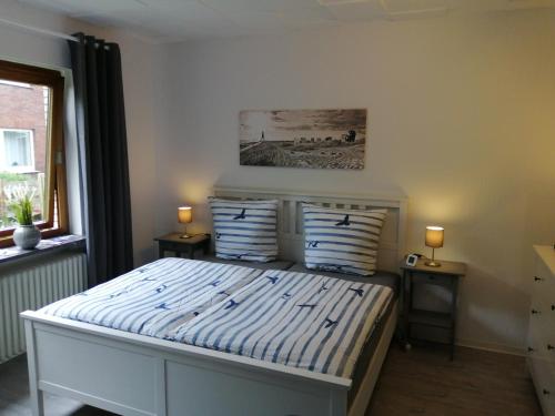 a bedroom with a bed with blue and white stripes at Steinmarner Bude 2 in Cuxhaven