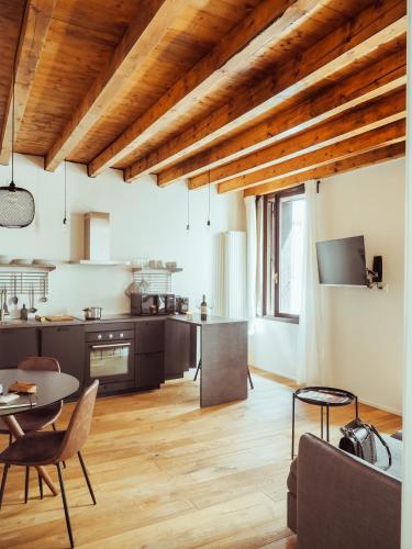 a kitchen and living room with wooden ceilings at BRE Apartments - Magellano in Vicenza