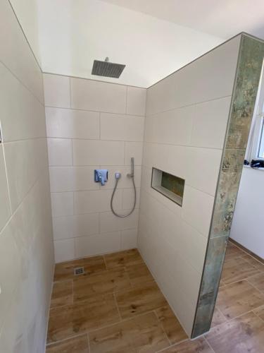 a shower in a bathroom with white tiles at Villa Schomberg in Spremberg