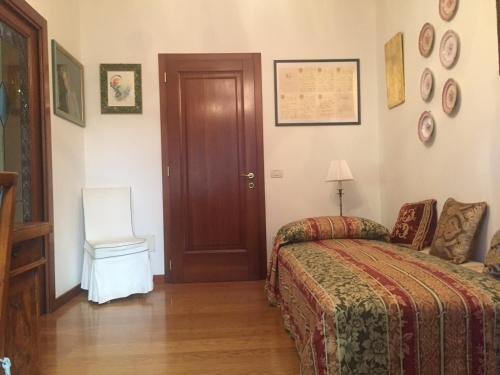 a bedroom with a bed and a door and a chair at Villa Liberty in Venice-Lido