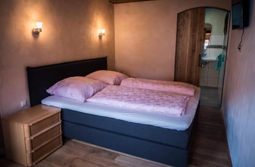 małą sypialnię z łóżkiem i lustrem w obiekcie Heuhof-Breitau Gästezimmer w mieście Sontra