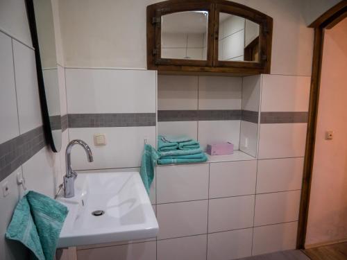 ein Badezimmer mit einem Waschbecken, einem Spiegel und Handtüchern in der Unterkunft Heuhof-Breitau Gästezimmer in Sontra