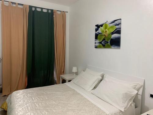 una camera con letto bianco e tenda verde di Palazzo Lamanna a Taranto