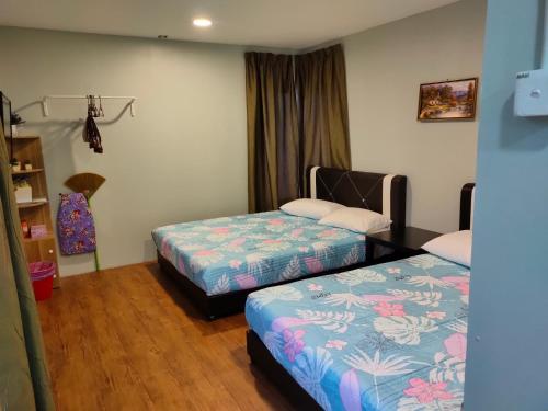 Habitación con 2 camas y estante para libros en Aleesa Roomstay, en Pasir Puteh