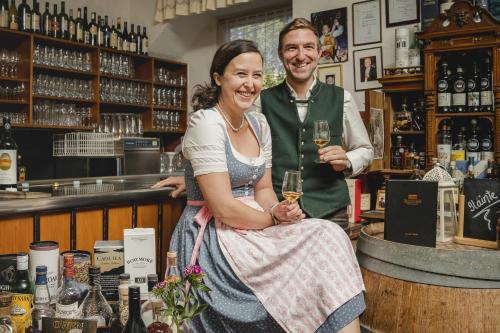 a man and a woman standing at a bar holding wine glasses at Hotel Drei Hasen in Mariazell